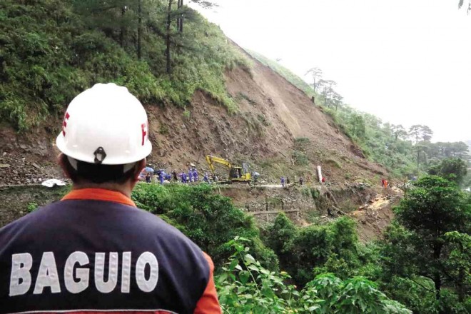 POLICEMEN, rescuers and DPWH personnel secure and clear a section of Kennon Road in Barangay Camp 6 at the boundary of Baguio City and Tuba, Benguet province, that was hit by a landslide on Monday morning. EV ESPIRITU/INQUIRER NORTHERN LUZON