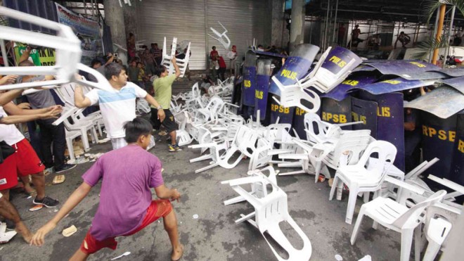 MONOBLOC MISSILES IN MAKATI  Supporters of Makati Mayor Junjun Binay, who has been ordered suspended anew by the Ombudsman, hurl Monobloc chairs at a phalanx of policemen using their shields like soldiers of the Roman Empire to protect themselves. The policemen were trying to enforce the suspension order.  JOEL LIPORADA/CONTRIBUTOR