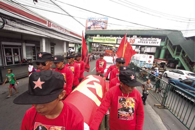 SUPPORTERS, some believed to be members of the New People’s Army, come out in the open in the streets of Davao City to bring the remains of slain guerrilla leader Leoncio Pitao to his resting place. At least 10,000 people attended the funeral march for Pitao, known in the guerrilla underground as Commander Parago. KARLOS MANLUPIG/INQUIRER MINDANAO 