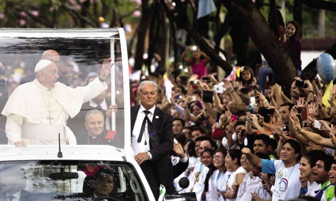 RELIGIOUS FERVOR Pope Francis rides in his popemobile to a stadium in Asuncion, Paraguay, to address religious pilgrims on Saturday. Francis lauded the strength and religious fervor of Paraguayan women while visiting the country’s most important pilgrimage site. AP