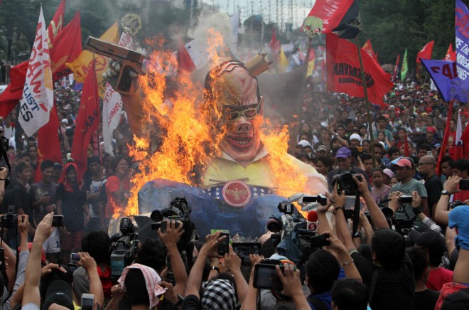 Miltants burn the effigy of president Benigno Aquino during the SONA rally along Commonwealth Avenue Quezon City. INQUIRER FILE PHOTO/RAFFY LERMA