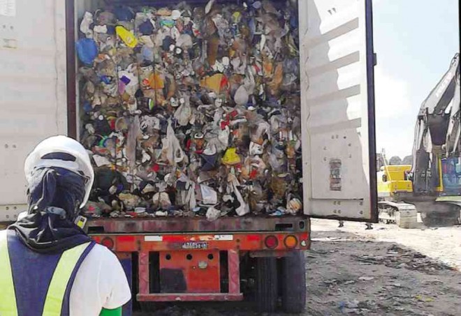 A CONTAINER van packed with trash illegally shipped from Canada in 2013 is unloaded at the sanitary landfill of the Metro Clark Waste Management Corp. in Capas, Tarlac.  PHOTO COURTESY OF MCWMC