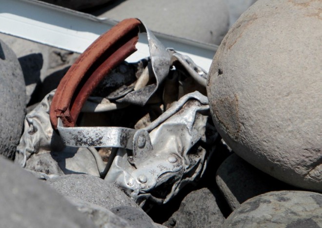 This picture taken on August 2, 2015 shows metallic debris found on a beach in Saint-Denis on the French Reunion Island in the Indian Ocean, close to where where a Boeing 777 wing part believed to belong to missing flight MH370 washed up last week.  A piece of metal was found on La Reunion island, where a Boeing 777 wing part believed to belong to missing flight MH370 washed up last week, said a source close to the investigation.  Investigators on the Indian Ocean island took the debris into evidence as part of their probe into the fate of Malaysia Airlines flight MH370, however nothing indicated the piece of metal came from an airplane, the source said.  AFP PHOTO / RICHARD BOUHET