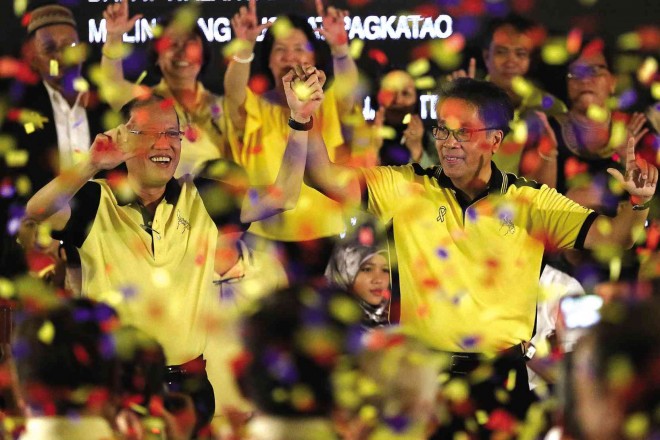 YOU’RE THE MAN!    Amid a rain of colorful confetti, with yellow dominating  of course,  President Aquino raises the hand of Interior Secretary Mar Roxas whom he endorsed as standard-bearer of the Liberal Party (LP) in next year’s presidential race, in what is billed   “A Gathering of Friends” by the LP held on  Friday at the historic Club Filipino in Greenhills, San Juan City. RAFFY LERMA 