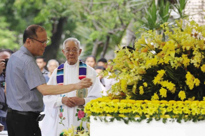ENDLESSLY REMEMBERED    President Aquino sprinkles holy water on the tombs of his parents, former Sen. Benigno Aquino Jr. and President Corazon Aquino, to mark the 6th anniversary of her death on Saturday. Beside him is President Cory’s spiritual adviser, Fr. Catalino Arevalo, who celebrated Mass for the gathering of the “yellow army” at the Manila Memorial Park in Parañaque City. NIÑO JESUS ORBETA 