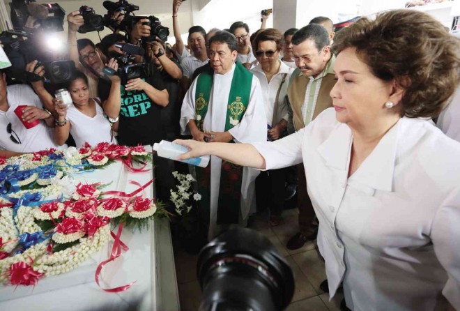 REEL ICON, REAL TRIBUTE. Actress Susan Roces, widow of movie legend Fernando Poe Jr., sprinkles Holy Water on his tomb during the Mass marking his 76th birth anniversary at Manila North Cemetery on Thursday. Also at the gathering was Poe’s bosom buddy, Manila Mayor Joseph Estrada (second from right). GRIG C. MONTEGRANDE