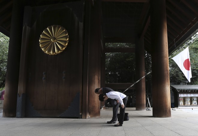 Visitors bow to pay respects to the war dead at Yasukuni Shrine in Tokyo Saturday, Aug. 15, 2015. Japan marked the 70th anniversary of the end of World War II. (AP Photo/Eugene Hoshiko)