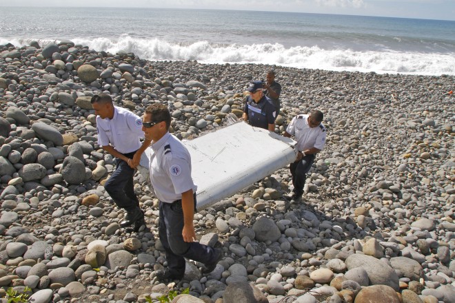 In this photo dated July 29, French police officers carry a piece of debris from a plane in Saint-Andre, Reunion Island. Air safety investigators, one of them a Boeing investigator, have identified the component as a "flaperon" from the trailing edge of a Boeing 777 wing, a US official said. Flight 370, which disappeared March 8, 2014, with 239 people on board, is the only 777 known to be missing. AP