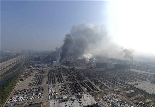 In this photo released by China's Xinhua News Agency, smoke rise from the site of explosions from a nearby building in the Binhai New Area in northeastern China's Tianjin municipality, Thursday, Aug. 13, 2015. AP