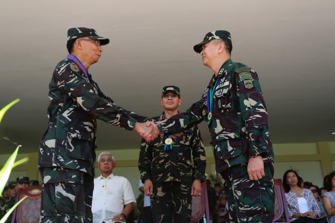  Lieutenant General Felicito Virgilio Manaog Trinidad Jr (left), outgoing Nolcom chief, congratulates incoming Nolcom Chief Major General Glorioso Miranda (right) as General Hernando DCA Iriberri, Chief of Staff AFP and Secretary of National Defense Voltaire Gazmin look on. Photos by Ssg Amable Milay Jr. PAF (PAO AFP)
