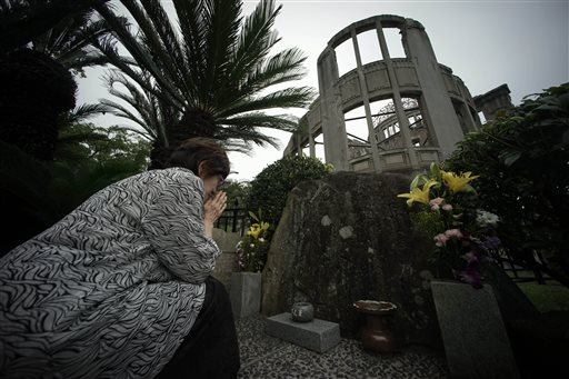 In this July 3, 2015 photo, Kimie Mihara, a survivor of the 1945 atomic bombing, prays at the cenotaph at the Atomic Bomb Dome, as it is known today in Hiroshima, Hiroshima Prefecture, southern Japan. AP