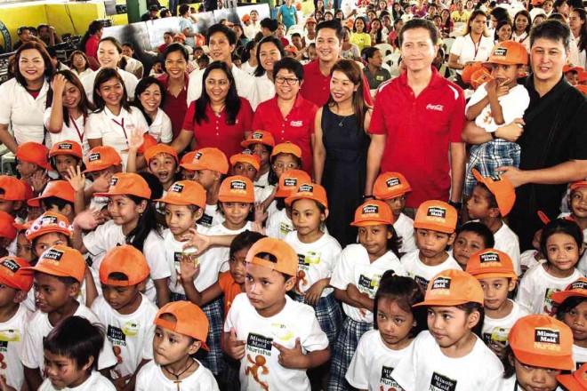 COCA-COLA executives and officials of the Food and Nutrition Research Institute and the sixth district of Quezon City with beneficiaries of Minute Maid Nurisha Supplementary Program at Sauyo Elementary School
