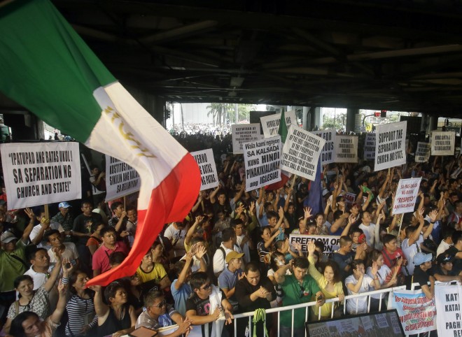 Members of the religious sect Iglesia Ni Cristo (Church of Christ) shout slogans during a protest against the Justice Department, Saturday, Aug. 29, 2015 in the suburban Mandaluyong city east of Manila, Philippines. The sect members, who earlier camped out for two days in Manila, are accusing Justice Secretary Leila De Lima of harassing the congregation by ordering an investigation into what it said false allegations by its expelled members. (AP Photo/Bullit Marquez)
