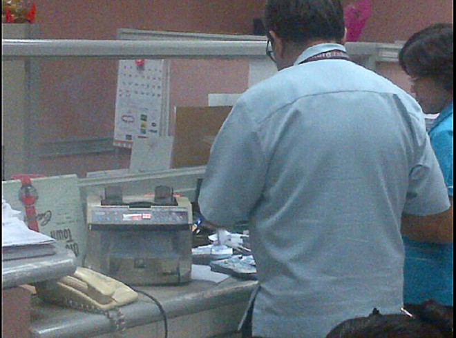 Using a counting machine, a cashier of the Sandiganbayan checks the P1.45 million cash Senator Juan Ponce Enrile produced to pay his bail for his plunder and 15 counts of graft cases stemming from the pork barrel scam. CONTRIBUTED PHOTO