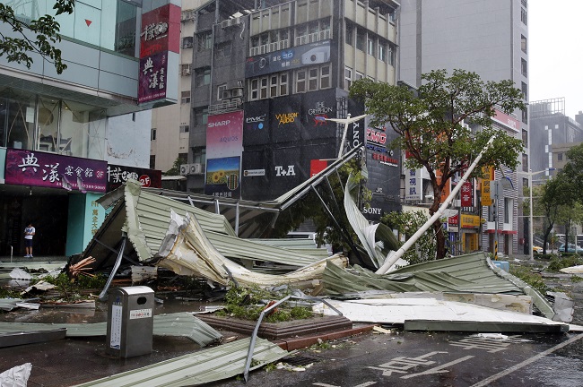 A street corner is filled with a mangled rooftop brought down by strong winds from Typhoon Soudelor in Taipei, Taiwan, Saturday, Aug. 8, 2015. Soudelor brought heavy rains and strong winds to the island Saturday with winds speeds over 170 km per hour (100 mph) and gusts over 200 km per hour (120 mph) according to Taiwan's Central Weather Bureau. (AP Photo/Wally Santana)