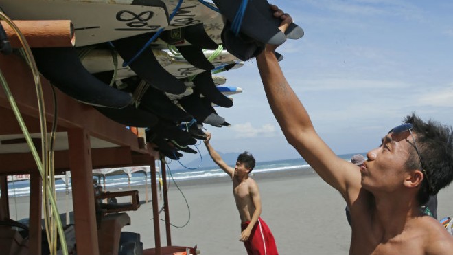 As Typhoon Soudelor approaches, surfers remove surf boards from the beach in Yilan County, northeastern Taiwan, Thursday, Aug. 6, 2015. Soudelor is expected to bring heavy rains and strong winds to the island Friday with winds speeds over 170 km per hour (100 mph) and gusts over 200 km per hour (120 mph) according to Taiwan's Central Weather Bureau. (AP Photo/Wally Santana)