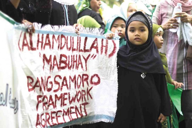 A CHILD carries a streamer expressing support for the peace process in a rally attended by thousands of residents in Cotabato City last year. KARLOS MANLUPIG/INQUIRER MINDANAO