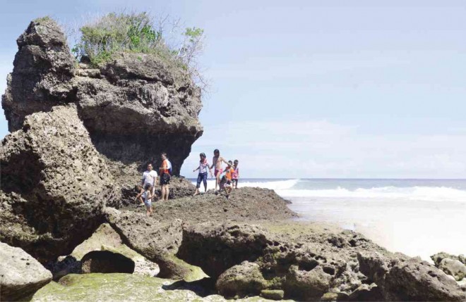 TOURISTS walk past rock formations after taking a dip in the waters of Governor Generoso town. GERMELINA LACORTE/INQUIRER MINDANAO