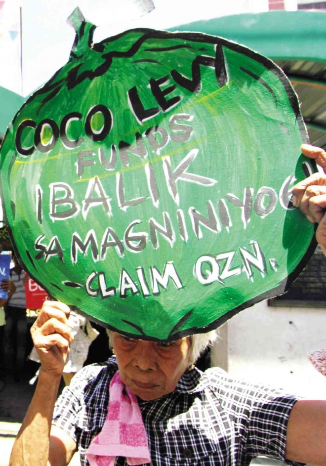 A COCONUT farmer carries a placard shaped like a coconut at a recent rally demanding the return of at least P74 billion in coconut levy funds to farmers. DELFIN T. MALLARI JR./INQUIRER SOUTHERN LUZON