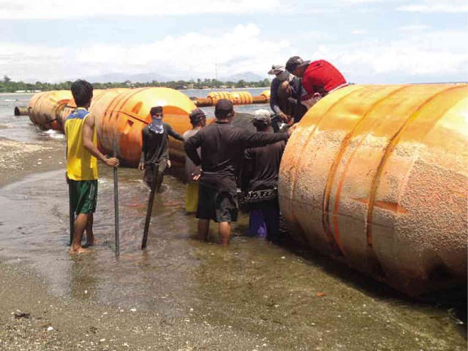 SEVERAL fishermen in Barangay San Agustin in Iba, Zambales province, dismantle the dredge floater assembly, extracting the screws from the steel pipes. They are asking the provincial government to allow them to sell these so they can make up for lost income from fishing. ALLAN MACATUNO/INQUIRER CENTRAL LUZON