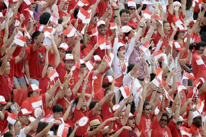 The crowds cheering as they do the Kallang Wave at the Padang. More than 26,000 people watched the parade at the Padang, while another 25,000 caught the action at The Float.ST PHOTO: KUA CHEE SIONG
