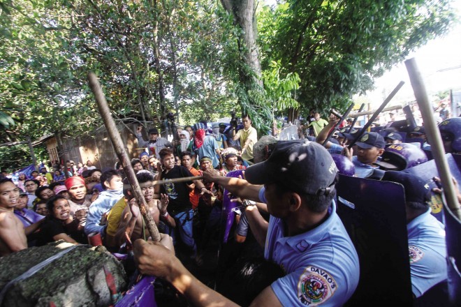 POLICEMEN,  believed to be acting on orders of Rep. Nancy Catamco, use truncheons on a group of Manobo people who sought shelter in a Protestant church compound in Davao City to escape what they said was increasing military presence in their communities in the provinces of Davao del Norte and Bukidnon. KARLOS MANLUPIG/INQUIRER MINDANAO 