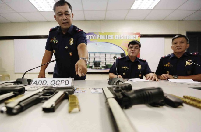 FROM LEFT: QCPD director Chief Supt. Edgardo Tinio, Task Force Tugis head Senior Supt. Ronald Lee and QCPD-CIDU head Chief Insp. Rodelio Marcelo present to reporters the firearms seized from a gunrunning suspect who turned out to be a policeman.  GRIG C. MONTEGRANDE