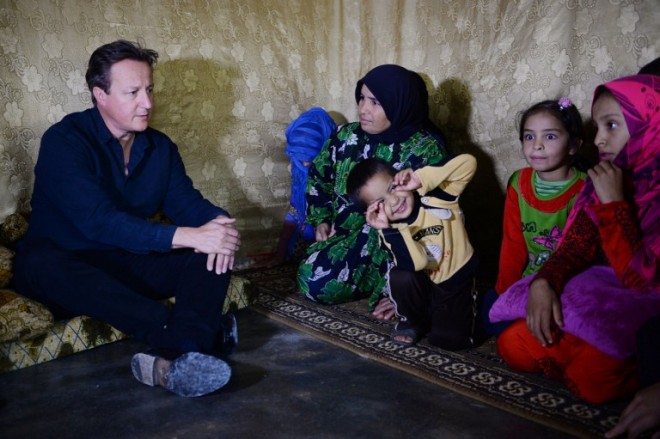 Britain's Prime Minister David Cameron (L) meets Syrian refugee families at a tented settlement camp in the Bekaa Valley on the Lebanese-Syrian border on September 14, 2015. Cameron arrived in Beirut on September 14 for a one-day visit to discuss the Syrian refugee crisis gripping the Middle East and Europe, a Lebanese government source said. Cameron was to visit a refugee camp in the Bekaa valley in eastern Lebanon, the source said. The country hosts more than 1.1 million Syrian refugees. is in the region to see conditons and meet those who have fled their homes in Syria.  AFP PHOTO / POOL / STEFAN ROUSSEAU