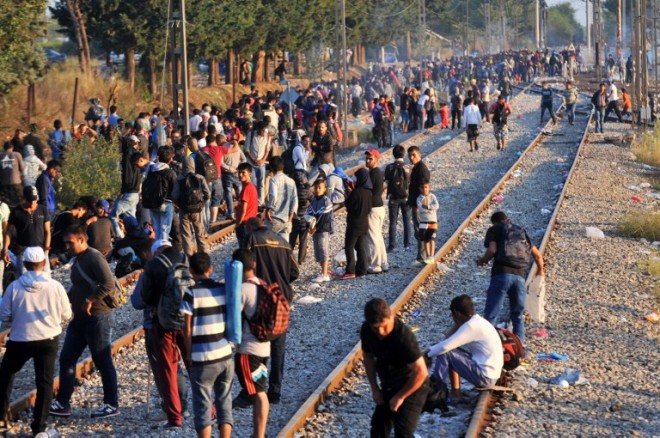 Migrants and refugees wait to cross the Greece-F.Y.R. Macedonia border near the village of Idomeni, in northern Greece on September 13, 2015. Three people, including a child, drowned when a boat carrying some 100 migrants capsized off Greece early on September 13, the Athens News Agency reported. It said the coastguard had rescued 68 people following the incident off the island of Farmakonisi in the Southern Aegean Sea.  AFP PHOTO /STR