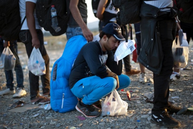 Migrant rests after crossing the Greece-Macedonia border near the town of Gevgelija on September 16, 2015. Migrants began to cross from Serbia into Croatia, desperate to find a new way into the European Union after Hungary sealed its border and a string of EU countries tightened frontier controls in the face of an unprecedented human influx. Pressure is building for a special EU summit to come up with solutions to the crisis, with the bloc bitterly split and free movement across borders -- a pillar of the European project -- in jeopardy, with Germany further calling it into question by boosting controls on parts of its frontier with France.      AFP PHOTO / NIKOLAY DOYCHINOV