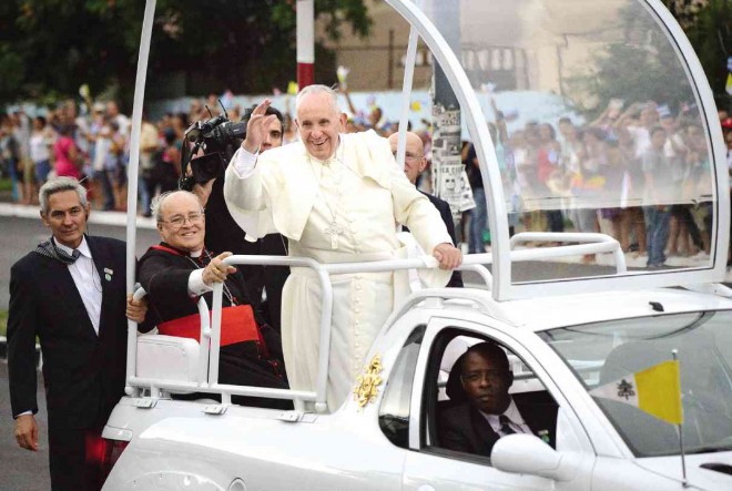 THE POPE IN HAVANA  People greet Pope Francis on his popemobile as he rides from the airport to downtown Havana after his arrival in Cuba on Saturday. AP