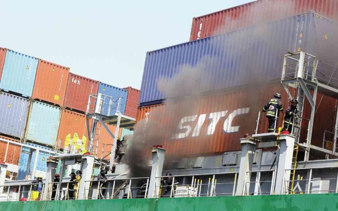 SHIP ON FIRE Firefighters battle a fire aboard the container ship MV Cape Moreton at the Manila International Container Terminal in Tondo, Manila, on Saturday. It took nine hours to put out the fire, which reportedly broke out after an explosion in the vessel’s cargo hold. No one was reported injured.     MARIANNE BERMUDEZ 