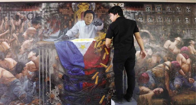 FACE-TO-FACE WITH MARTIAL LAW MEMORIES  Authoritarian President Ferdinand Marcos seems to be confronting young Batanes artist Randalf Dilla in this mural titled “Salvaged Memories, Salvaged Lives.” The oil and acrylic mural was commissioned by Hiraya Gallery to remind Filipinos of the horrors of martial law. It is part of the exhibit “Tyranny of Hindsight,” which opens on Sept. 23 in connection with the 43rd anniversary of the declaration of martial rule. Dilla, 28, was not yet born at the time, but assiduous research gave him enough insight into what he described as a reality that should not be forgotten or rewritten. MARIANNE BERMUDEZ