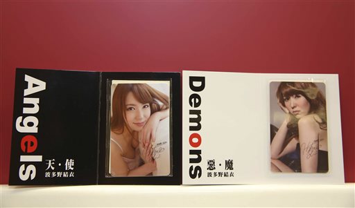 In this photo taken on Aug. 26, 2015, by the Central News Agency, two special edition swipe cards for Taiwan's mass transit are seen on display featuring the clothed image of  27-year-old, Japanese porn star Yui Hatano, in Taipei, Taiwan.  Despite strong opposition, the 15,000 limited-edition cards sold out within hours overnight via a telephone hotline. (Central News Agency via the AP)