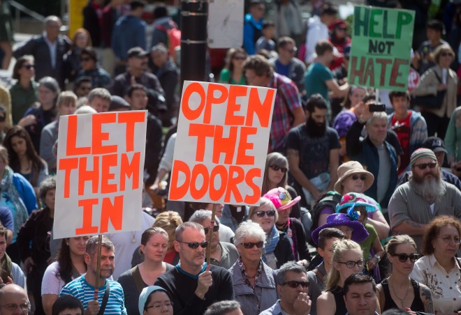 People attend a rally calling on the Canadian government to allow more refugees from Syria into the country Sunday, Sept. 6, 2015, in Vancouver, British Columbia. (Darryl Dyck/The Canadian Press via AP) MANDATORY CREDIT