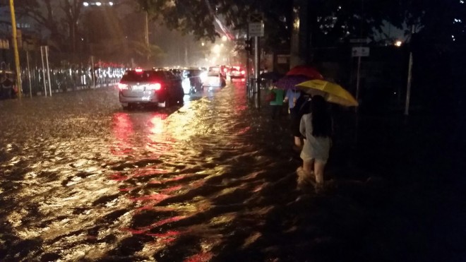 Commuters wade through knee-level waters in Chino Roces Avenue Makati city