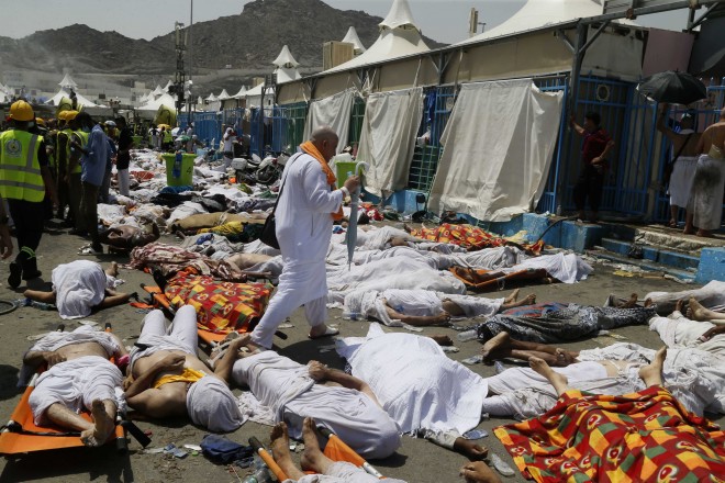 A muslim pilgrim walks through the site where dead bodies are gathered in Mina, Saudi Arabia during the annual hajj pilgrimage on Thursday, Sept. 24, 2015. Hundreds were killed and injured, Saudi authorities said. The crush happened in Mina, a large valley about five kilometers (three miles) from the holy city of Mecca that has been the site of hajj stampedes in years past. (AP Photo)