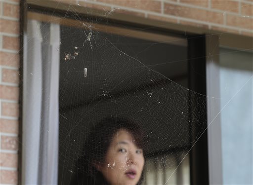 In this Friday, Sept. 4, 2015 photo, Naoko Kanai watches a spider's web at her house after returning home for the first time in about two months, in Naraha town, Fukushima prefecture, northeastern Japan. This past weekend, Naraha became the first of seven towns that had been entirely evacuated to reopen since the March 11, 2011, disaster, when a tsunami slammed into the Fukushima Dai-ichi nuclear power plant, causing meltdowns and a massive radiation leak. Kanai, a 50-year-old homemaker, is among those having trouble deciding whether to return to Naraha permanently. (AP Photo/Koji Sasahara)