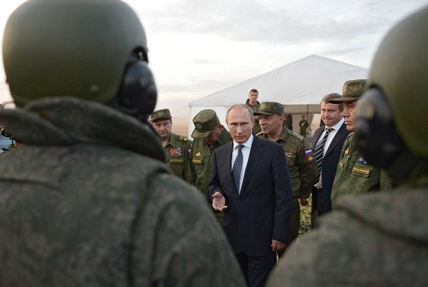 FILE -  In this Saturday, Sept. 19, 2015 file pool photo, Russian President Vladimir Putin, center, meets with officers after military exercises at Donguz range in Orenburg region, Russia. With dozens of Russian combat jets and helicopter gunships lined up at an air base in Syria, Russian President Vladimir Putin is ready for a big-time show at the United Nations General Assembly. Observers expect the Russian leader to call for stronger U.N.-sanctioned global action against the Islamic State group and possibly announce some military moves in his speech on Monday, Sept. 28, 2015. (Alexei Nikolsky/RIA-Novosti, Kremlin Pool Photo via AP, file)