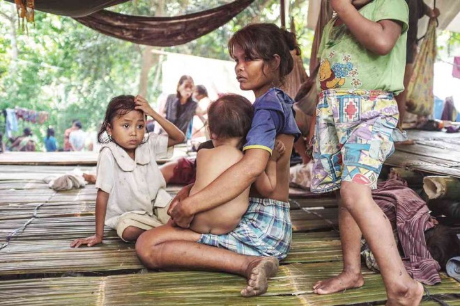 A MANOBO mother breast-feeds her child inside a makeshift house in an evacuation center in Davao City. Hundreds of “lumad” were displaced from Talaingod, Davao del Norte province,  following a series of attacks allegedly committed by paramilitary and government forces.     KARLOS MANLUPIG/INQUIRER MINDANAO
