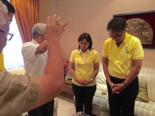Liberal Party standard-bearer Mar Roxas (right) and CamSur representative Leni Robredo are being prayed over by Archbishop Rolando Tria Tirona. PHOTO FROM REP. CAROL LOPEZ
