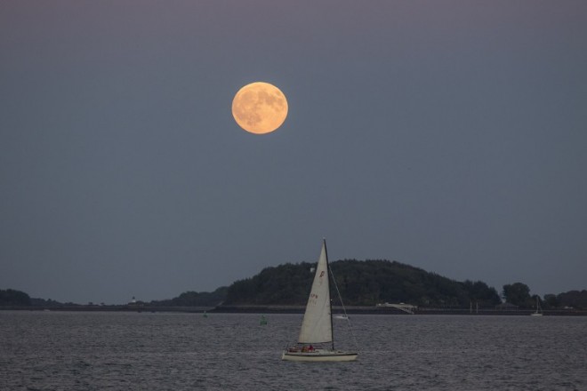 BOSTON, MA - SEPTEMBER 27: The Super Blood Moon rises over a sailboat in Boston Harbor on September 27, 2015 in Boston, Massachusetts. The Super Moon coincides with a total lunar eclipse, a rare combination that last occured in 1982.   Scott Eisen/Getty Images/AFP