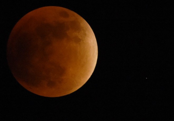 A swollen "supermoon" is seen during the stages of a total eclipse in Caracas on September 27, 2015. For the first time in decades, the double spectacle of a swollen "supermoon" bathed in the blood-red light of a total eclipse can be seen. The celestial show, visible from the Americas, Europe, Africa, west Asia and the east Pacific, will be the result of the Sun, Earth and a larger-than-life, extra-bright Moon lining up for just over an hour.  AFP PHOTO/JUAN BARRETO