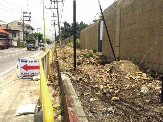 GREEN TURNING GRAY. The once tree-lined sidewalk of South Avenue along the walls of Manila South Cemetery is now clear of “obstructions” and ready for paving under a road-widening project in Makati City. The city government issued a permit last month for the removal of the trees. MARICAR B. BRIZUELA