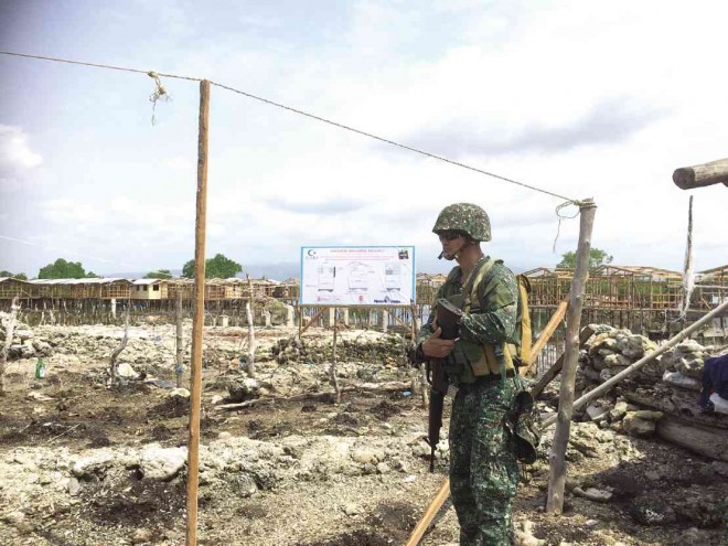 A MARINE stands guard in the village of Talon-Talon on Sumariki Island, one of the areas that came under siege by followers of Nur Misuari in Zamboanga City in 2013. The place is now being rehabilitated with permanent homes being built on stilts.          JULIE S. ALIPALA/INQUIRER MINDANAO