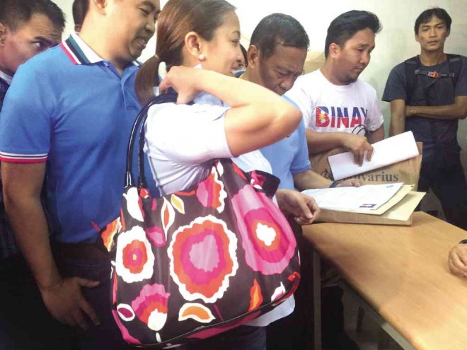 Makati Rep. Abigail Binay is flanked by her brother Junjun and father, Vice President Jejomar Binay, as she files her certificate of candidacy for mayor at the local Comelec office on Thursday. The Binays are fielding her for the city’s top post after the Ombudsman dismissed Junjun as mayor and disqualified him from public service.   Maricar B. Brizuela