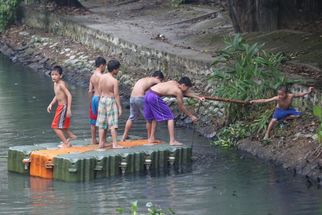 October 17, 2015 Rainy Weekend- Young boys ride an floating flatform along the Pasig river on saturday morning, as Typhoon Lando enters the country saturday afternoon in Isabela and Aurora provinces.  INQUIRER/ MARIANNE BERMUDEZ