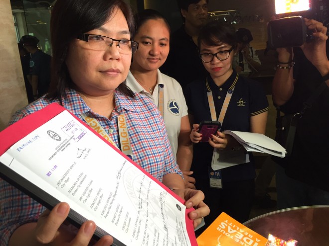 Ma. Lourdes Agustin, officer-in-charge Regional Director of DILG-NCR, holding a copy of the Ombudsman order sacking suspended Makati Mayor Junjun Binay she served with two DILG staff on Wednesday. JULLIANE LOVE DE JESUS/INQUIRER.net 