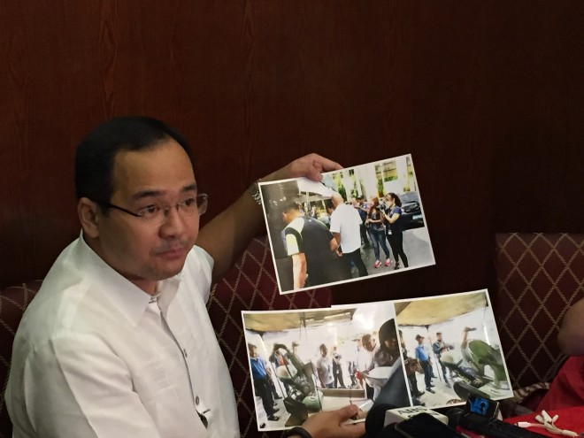 Lawyer Rico Quicho, spokesman for political affairs of Vice President Jejomar Binay, shows to the media photos of police escorts from the Department of Interior and Local Government (DILG) and the Philippine National Police (PNP) who served the dismissal order of suspended Makati Mayor Jejomar Binay. The Binay's camp called this as harrasment.