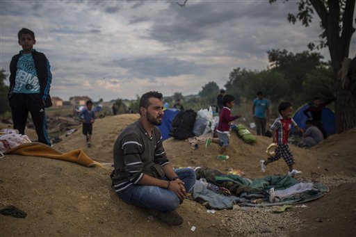 In this photo taken on Friday, Sept. 11, 2015, Mohammed al-Haj waits to be registered by local authorities in the Serbian town of Presevo. The 26-year-old from Aleppo was one of more than 600,000 migrants and refugees who flowed into Europe so far this year. The Associated Press followed Mohammed on nearly every step of his 2,500-mile journey in September, starting from Killis, Turkey, where his family lived for a year after escaping Syria. (AP Photo/Santi Palacios)